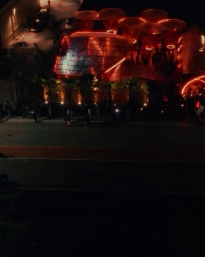 O Aura Beach Club aceso em vermelho à noite, visto de cima