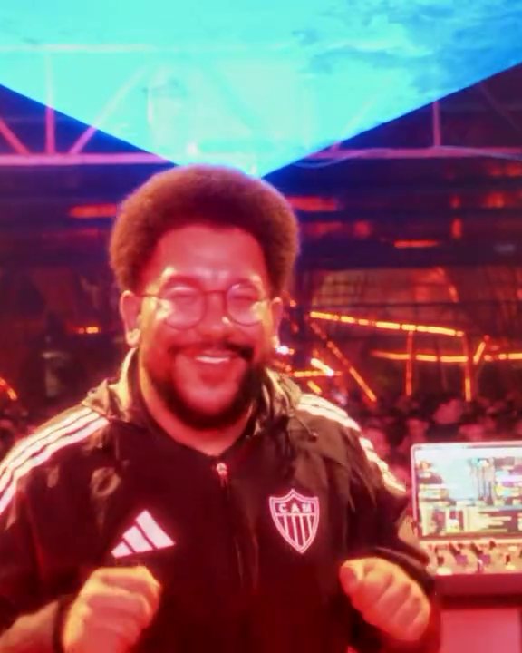 DJ sorrindo sob os lasers do Aura